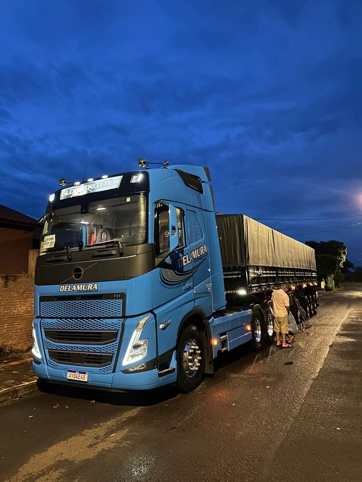 Volvo FH azul da Delamura com graneleiro à noite
